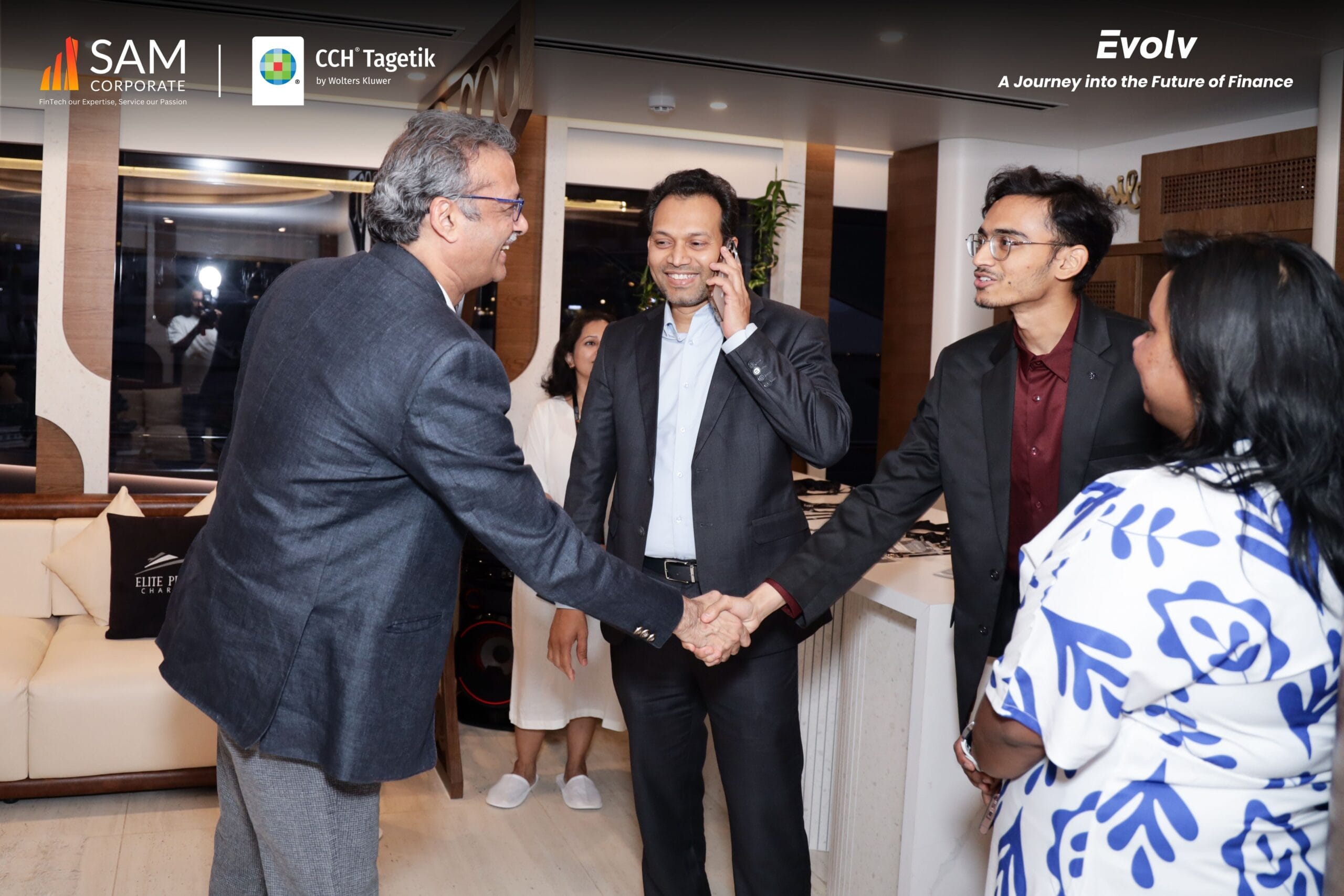Executives shaking hands and connecting at the exclusive Evolv event, hosted by SAM Corporate and sponsored by CCH Tagetik.