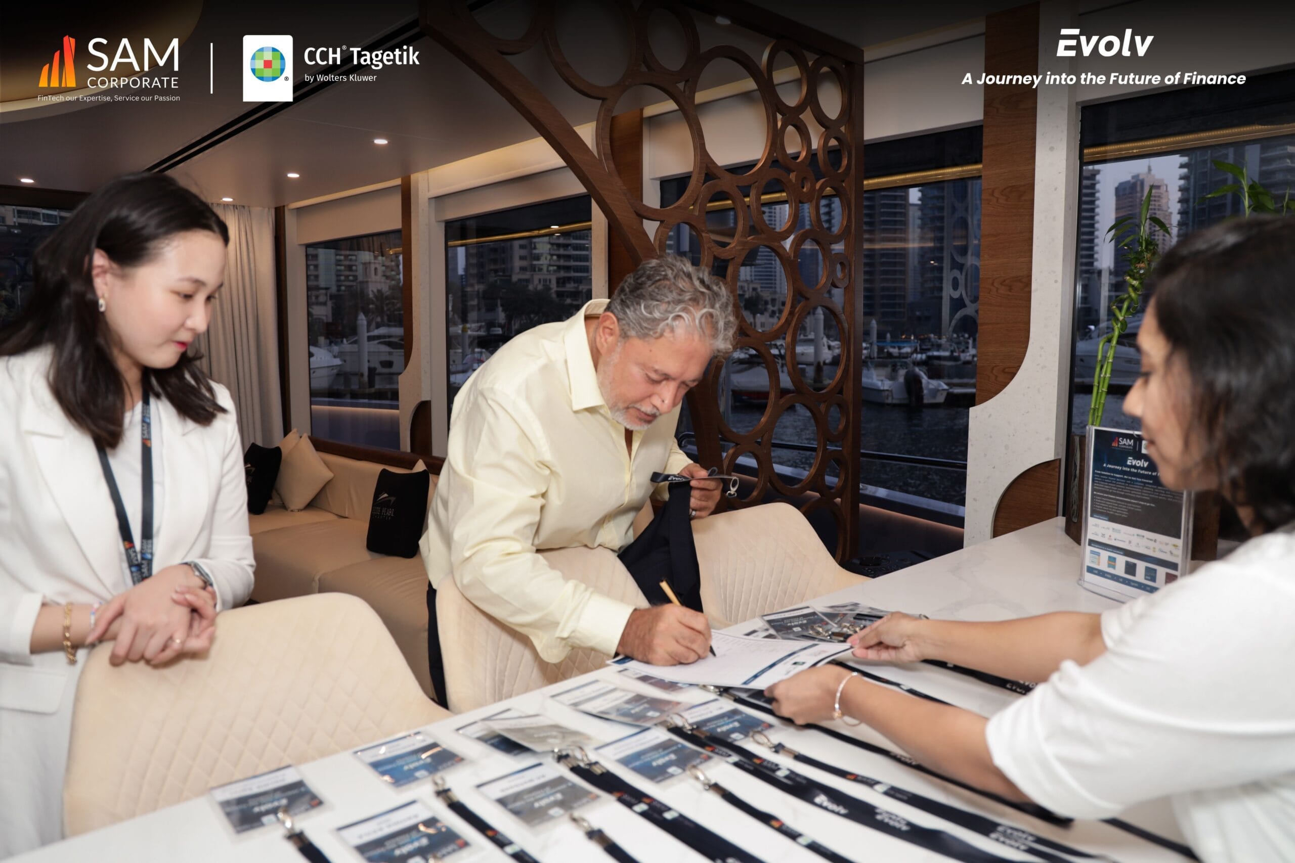 Evolv event registration check-in with SAM Corporate and CCH Tagetik team in yacht hallway.