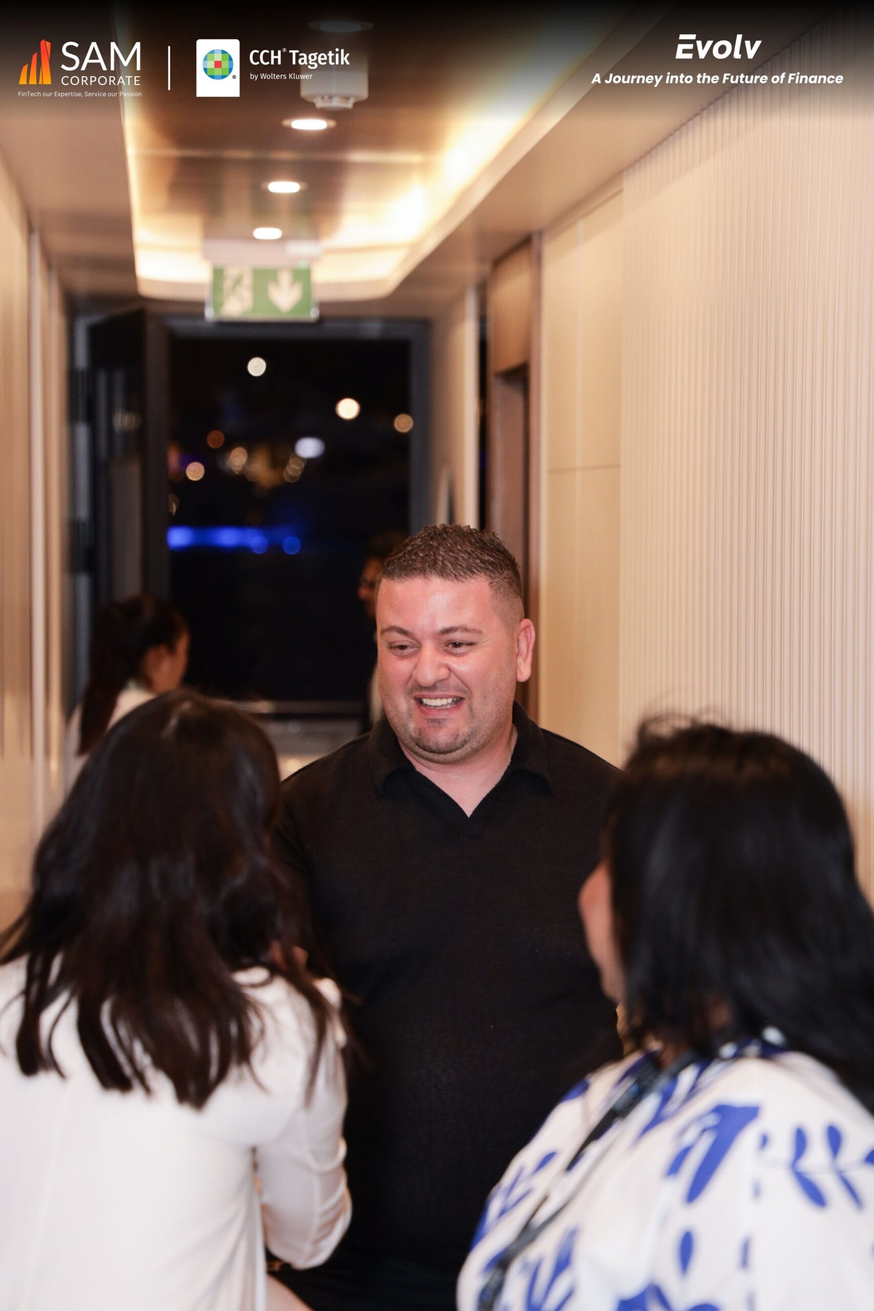 A smiling guest engaging in conversation at the Evolv event, an industry gathering hosted by SAM Corporate and CCH Tagetik focused on the future of finance.