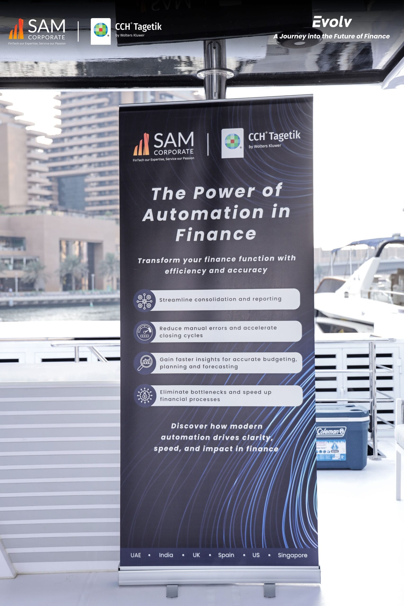 A vertical banner display at the Evolv event, detailing "The Power of Automation in Finance," presented by SAM Corporate and CCH Tagetik, highlighting efficiency and accuracy in financial functions.