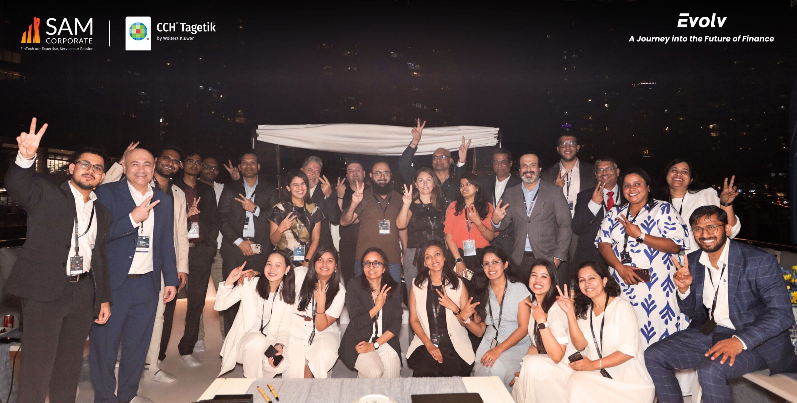 A large group of SAM Corporate and CCH Tagetik executives and guests posing and smiling on the yacht deck at the Evolv event.