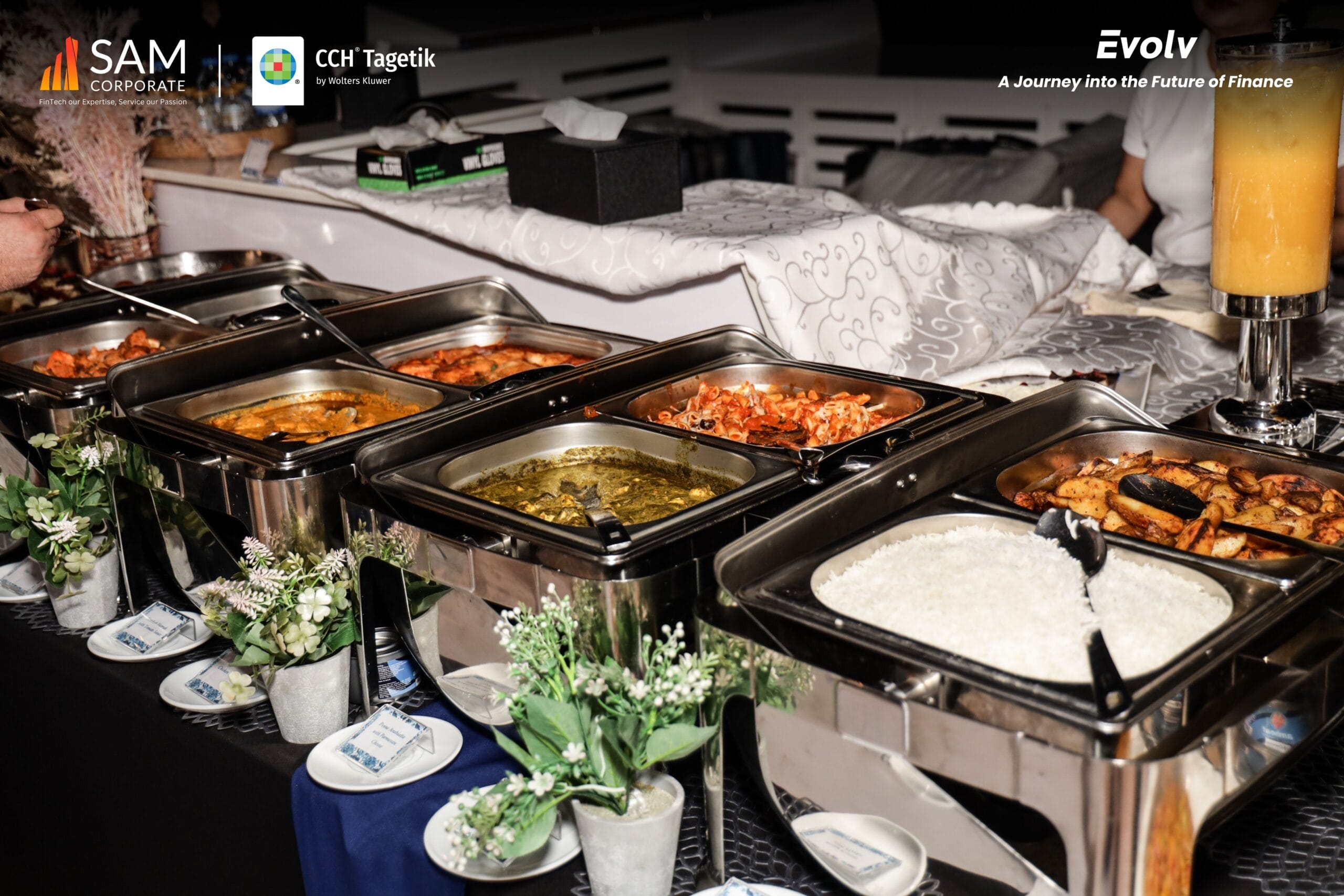 A buffet spread featuring salads, appetizers, and hot food trays at the Evolv networking event hosted by SAM Corporate and CCH Tagetik.