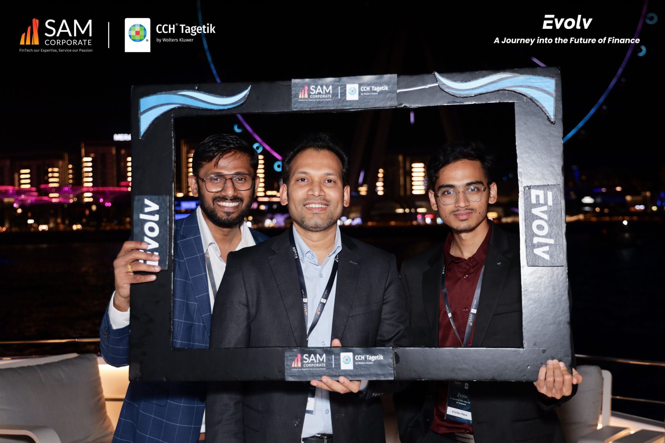 Three SAM Corporate and CCH Tagetik executives smiling in a photo booth on the yacht during the Evolv networking event.