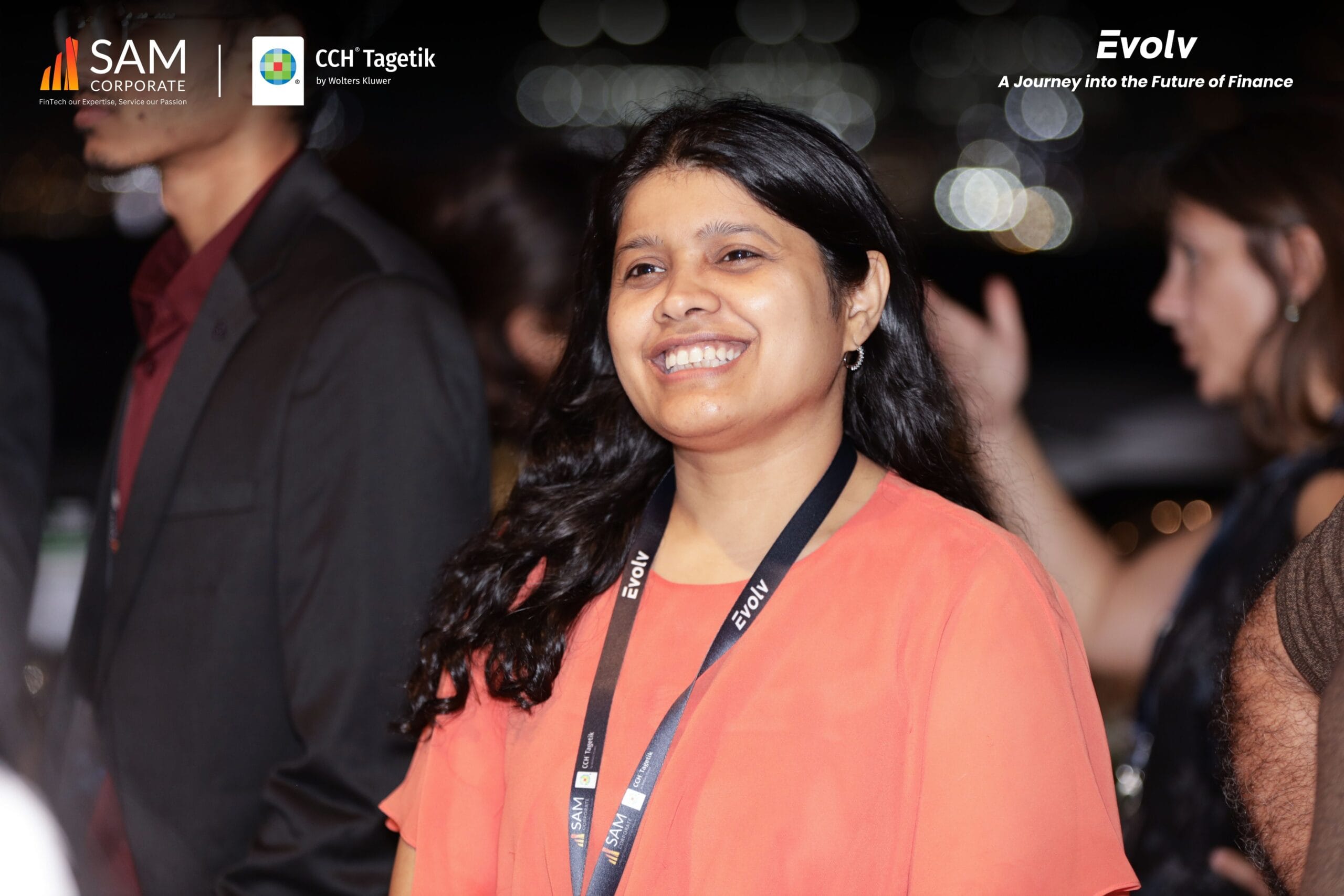 A guest smiles on the yacht deck, wearing an Evolv lanyard at the professional networking event by SAM Corporate and CCH Tagetik.