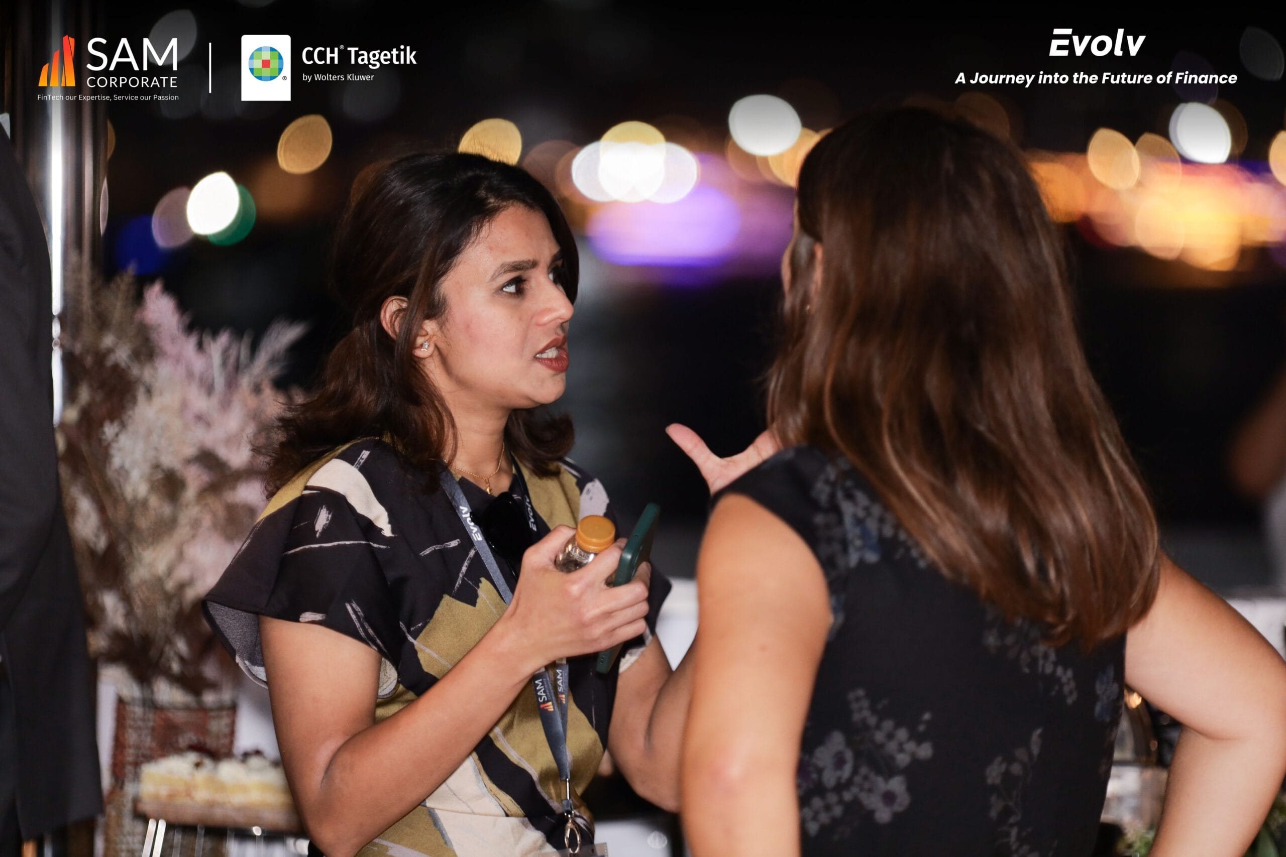 Professional women engaged in conversation and networking on the yacht deck at the Evolv event by SAM Corporate and CCH Tagetik.