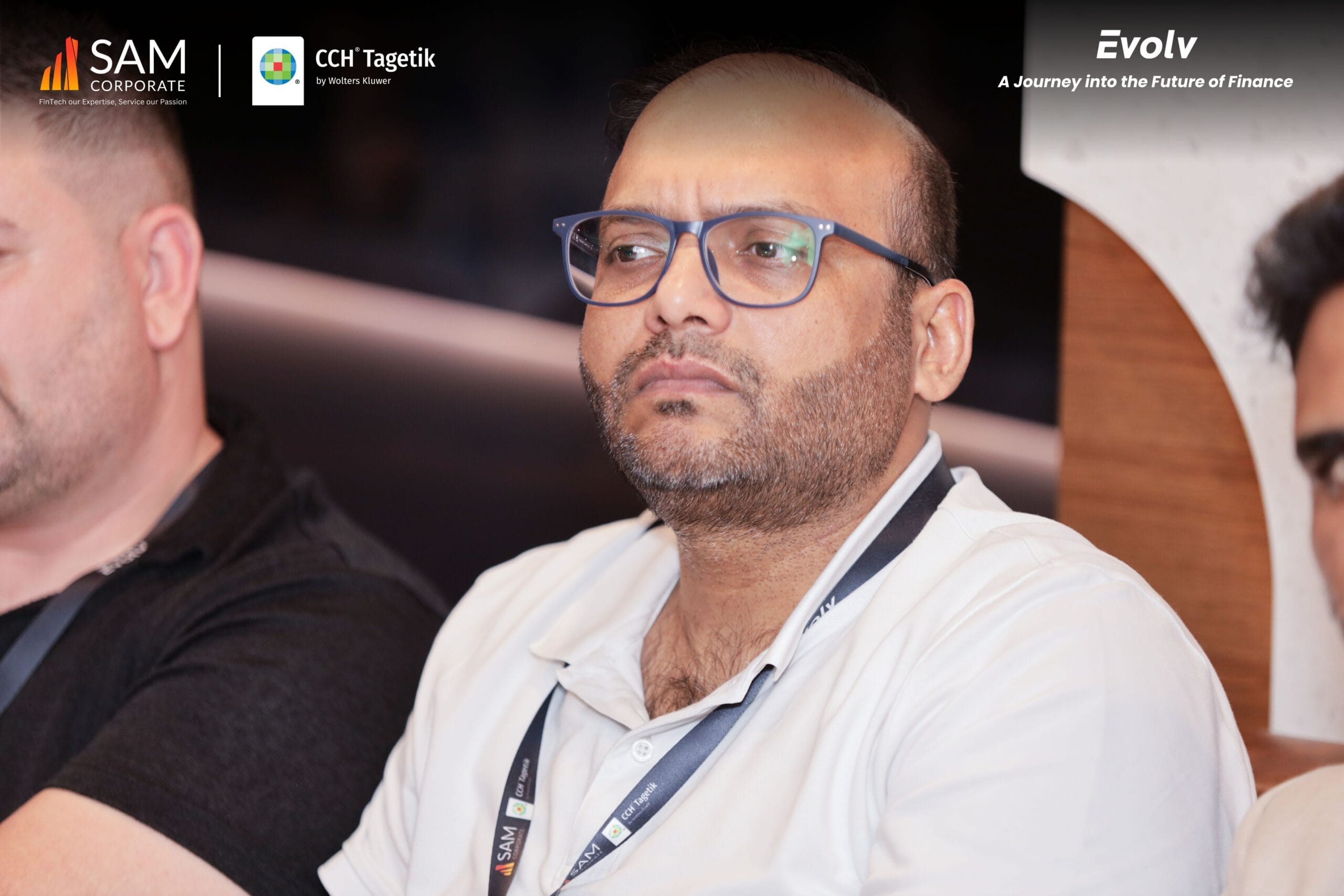 An executive from SAM Corporate or CCH Tagetik listening intently during a key session at the Evolv finance event.