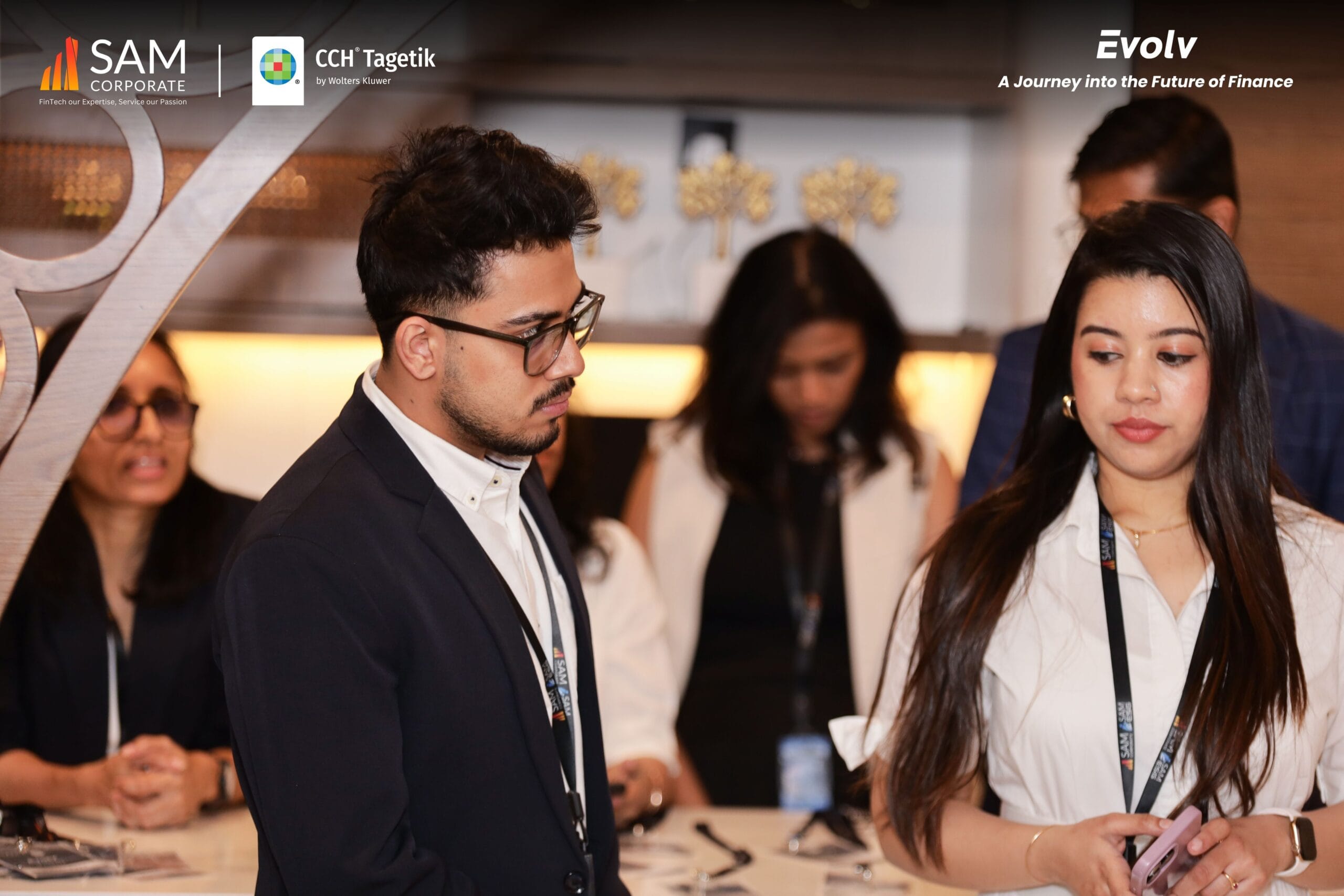 Focused attendees engaging with event materials at a discussion point during the Evolv networking event by SAM Corporate and CCH Tagetik.