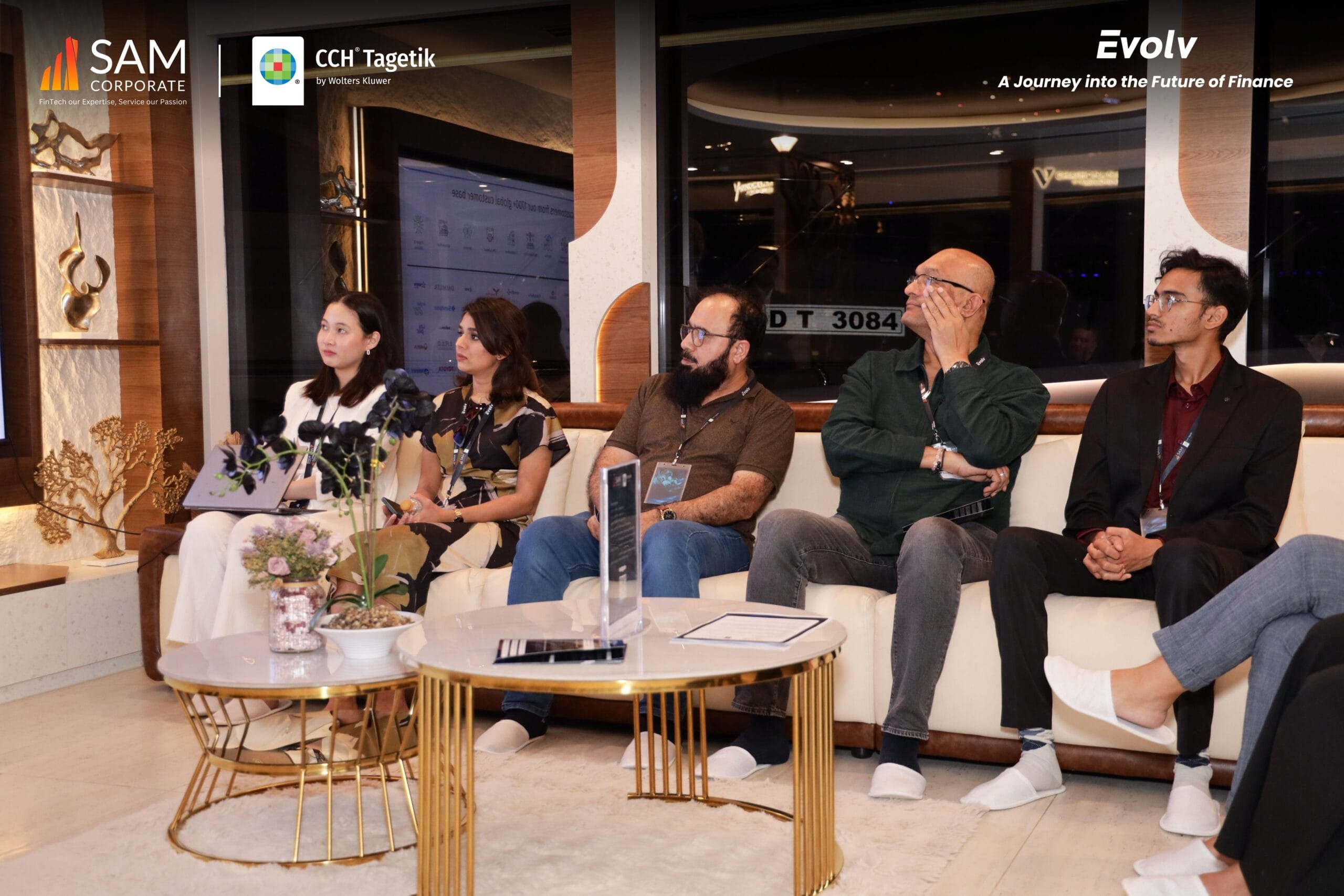 Group of male and female finance executives seated on a couch listening attentively at the Evolv event by SAM Corporate and CCH Tagetik.
