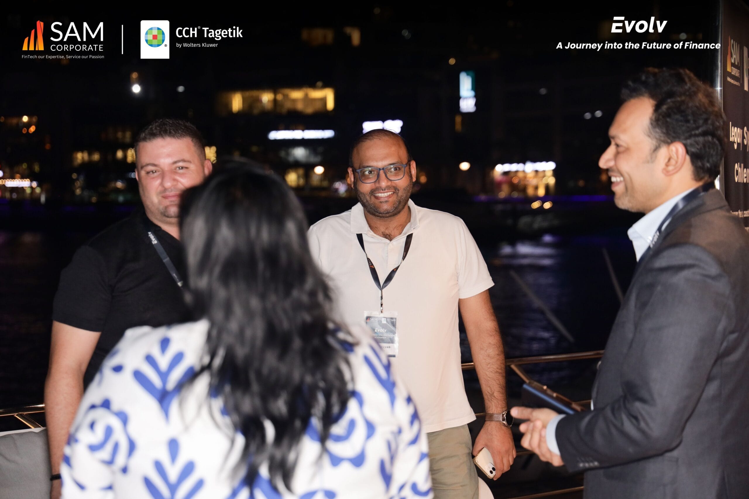 Attendees smiling and networking on the outdoor deck during the Evolv event by SAM Corporate and CCH Tagetik.