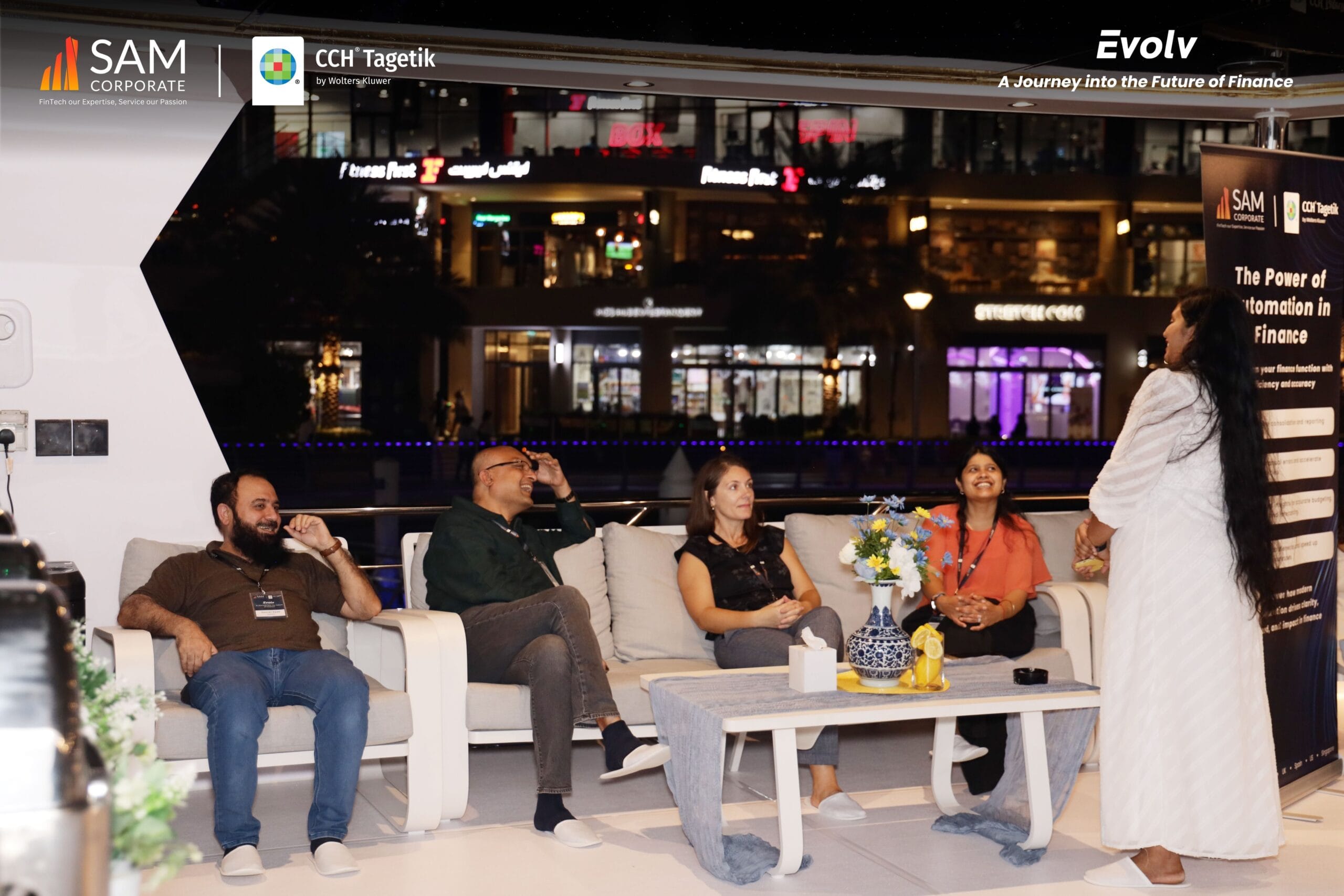 Attendees seated near a banner about 'The Power of Automation in Finance' at the Evolv event by SAM Corporate and CCH Tagetik.