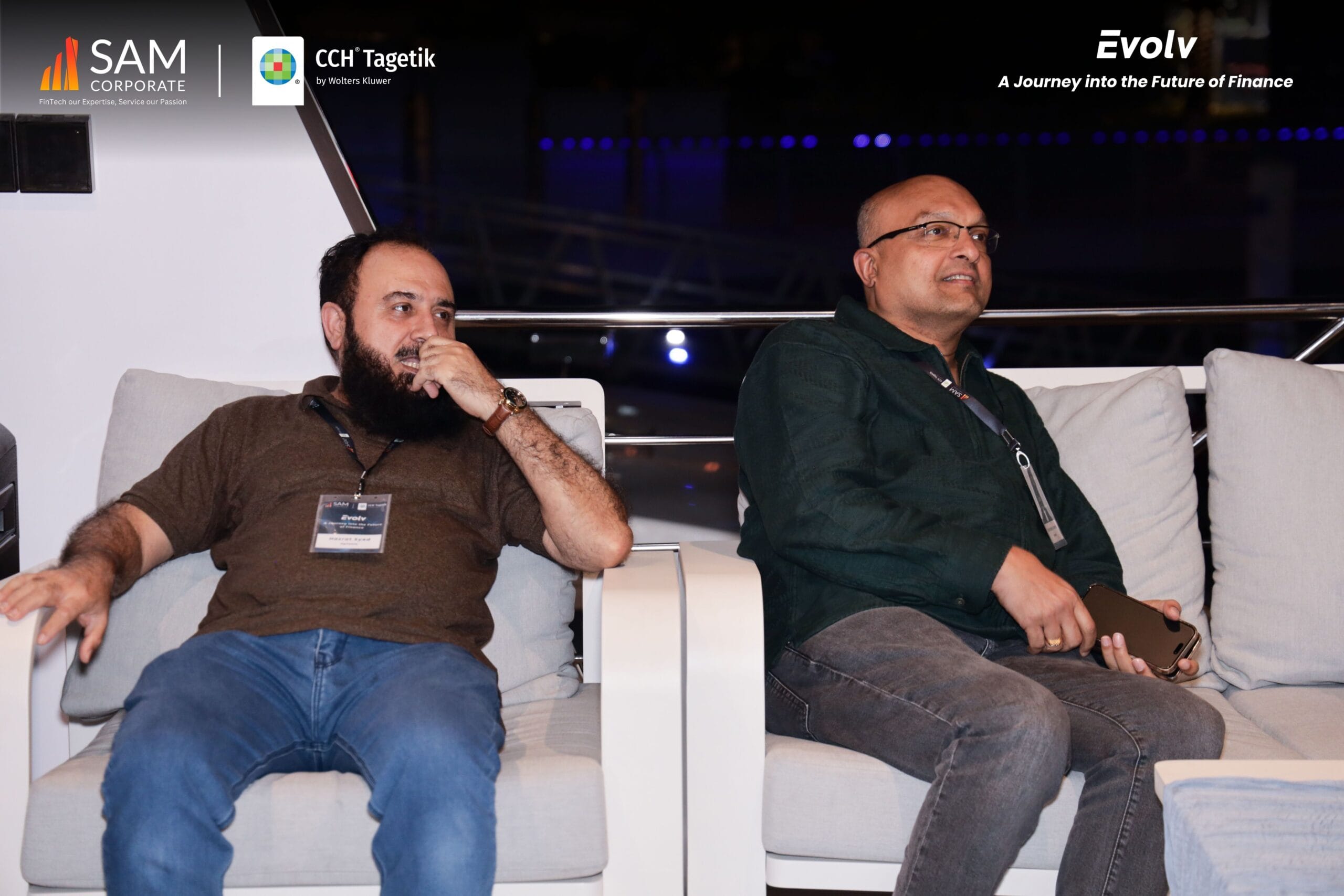 Two attendees seated comfortably during a session at the Evolv event, sponsored by SAM Corporate and CCH Tagetik.