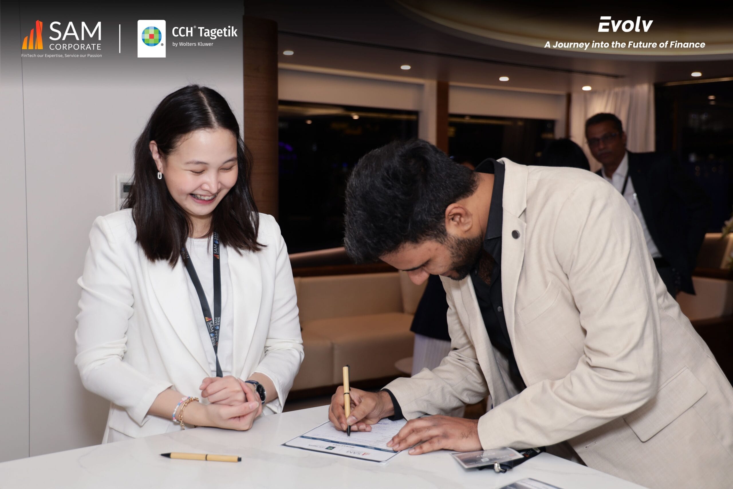 Event staff assisting an attendee with registration paperwork for the Evolv finance summit by SAM Corporate and CCH Tagetik.