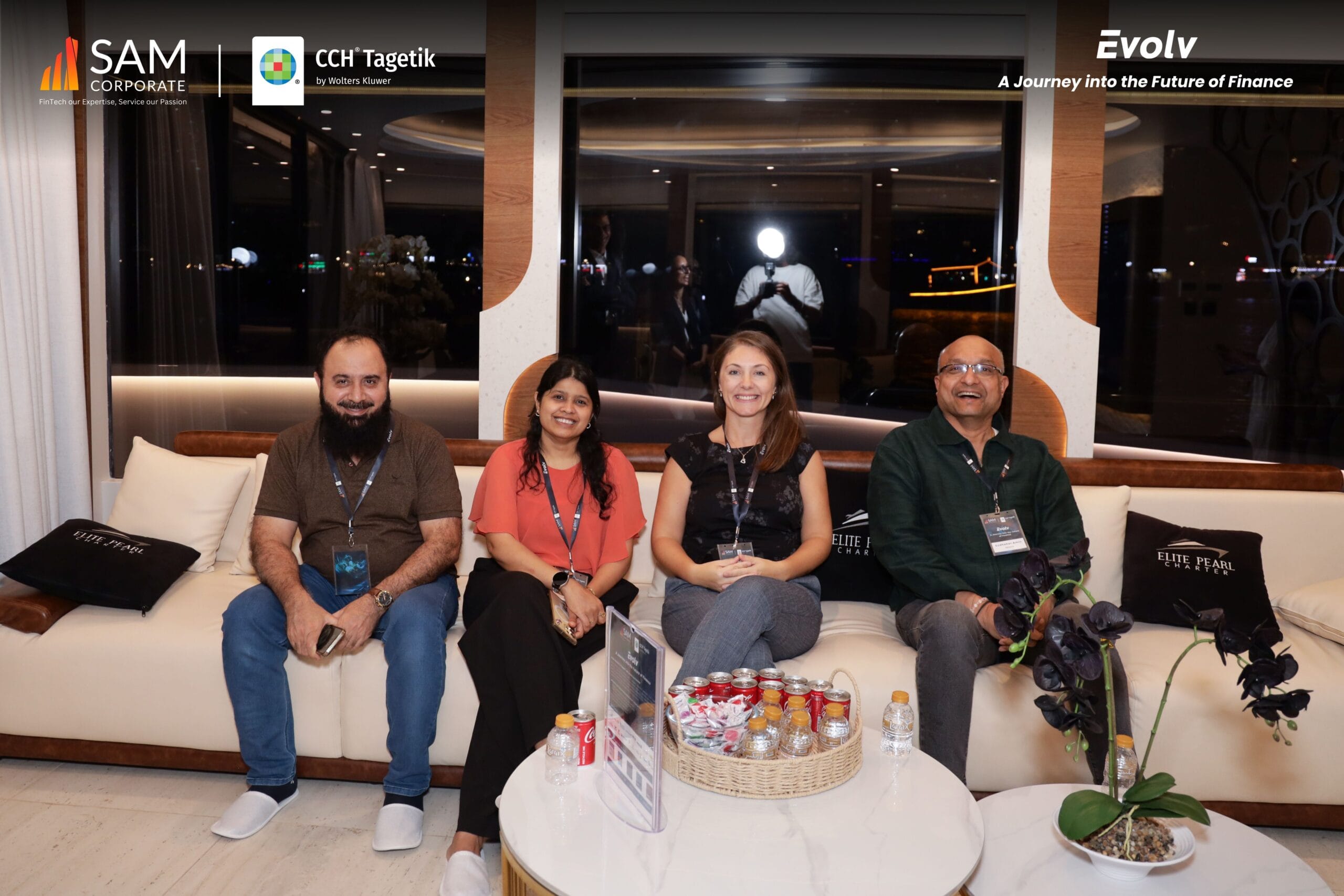 Four smiling attendees seated together at the exclusive Evolv event, sponsored by SAM Corporate and CCH Tagetik.