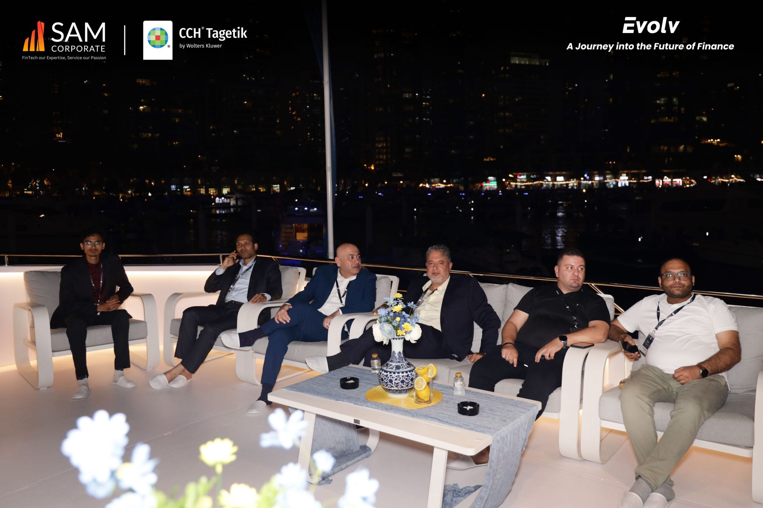 Group of finance professionals relaxing on an outdoor deck during the evening Evolv networking event by SAM Corporate and CCH Tagetik.
