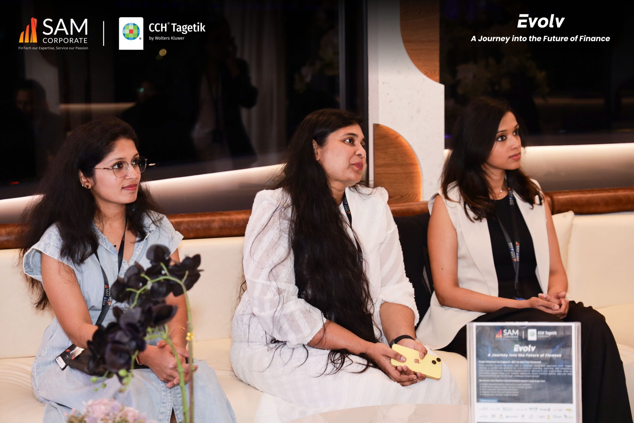 Three female attendees listen to a presentation at the Evolv finance event by SAM Corporate and CCH Tagetik.