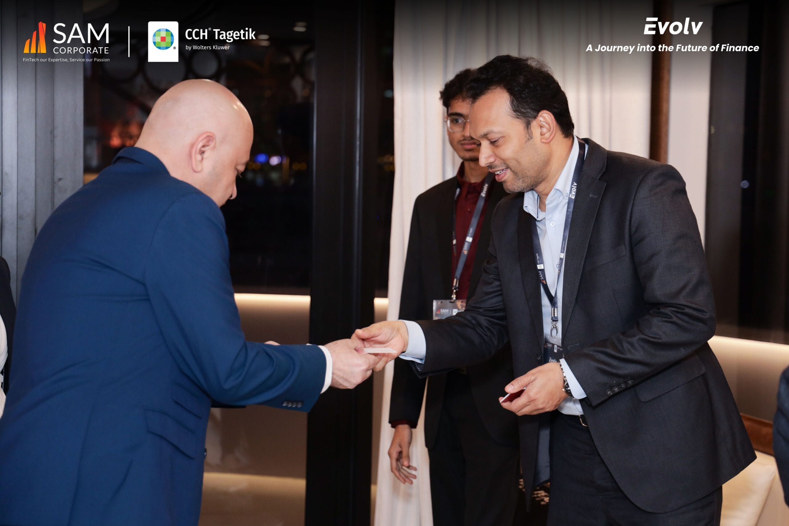 Business card exchange between executives at the Evolv event, an exclusive gathering by SAM Corporate and CCH Tagetik.