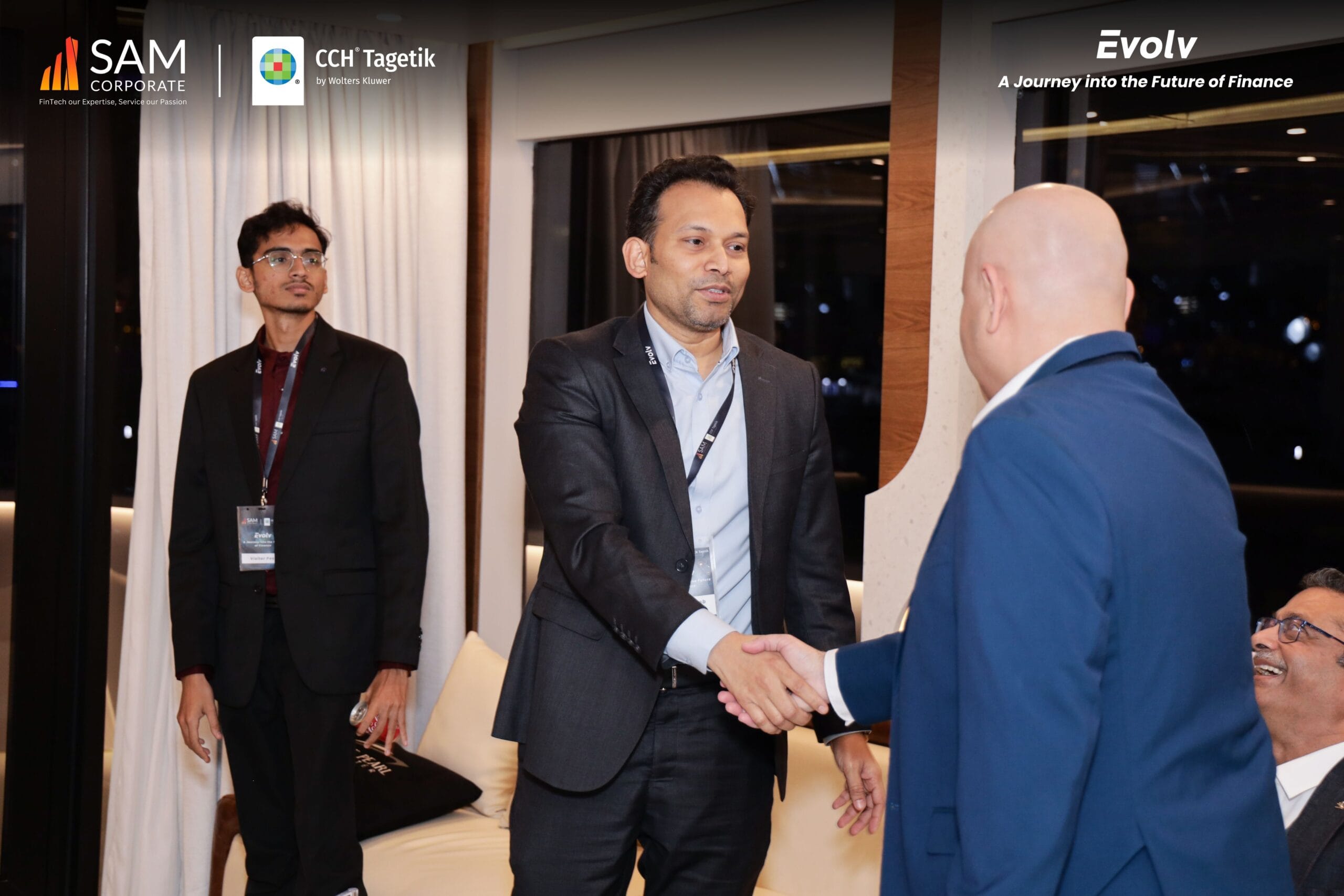 Two executives shaking hands at the Evolv finance event, hosted in partnership by SAM Corporate and CCH Tagetik.