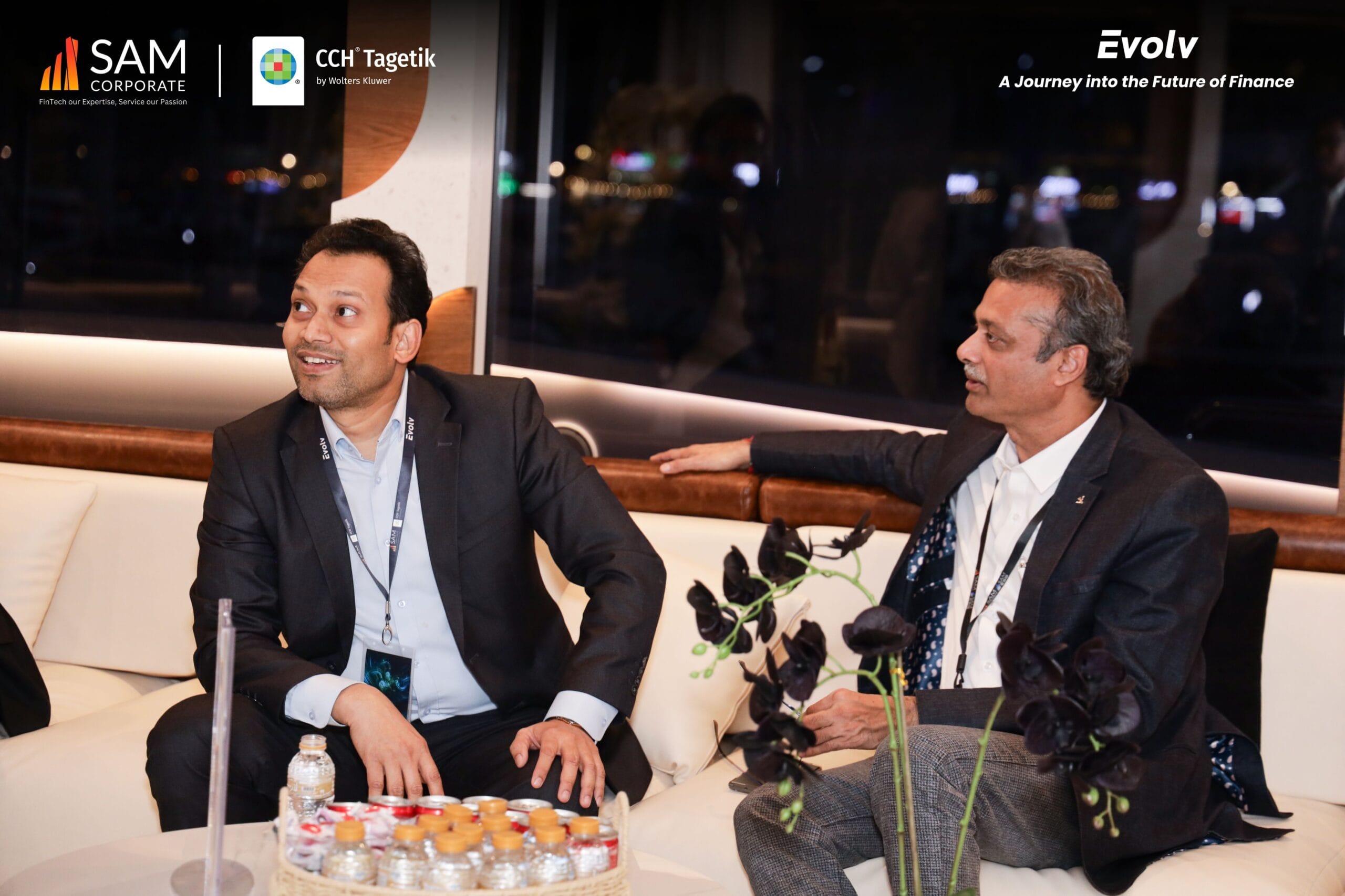 Two executives seated and engaging in a discussion during the Evolv event, powered by SAM Corporate and CCH Tagetik.
