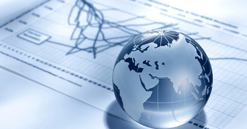 Glass globe placed on financial chart symbolizing global sustainability reporting and market performance