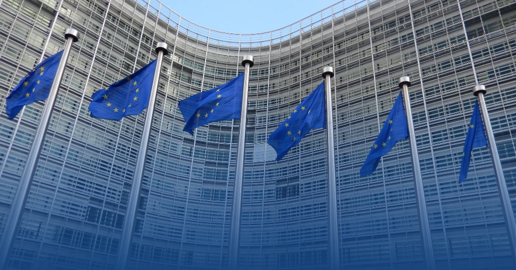 Close-up of a waving European Union flag with yellow stars on a blue background representing EU regulations and policy.