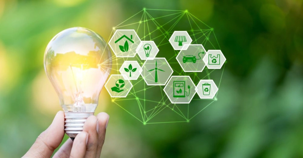 A hand holding a glowing light bulb connected to a network of green icons for solar, wind, and recycling.